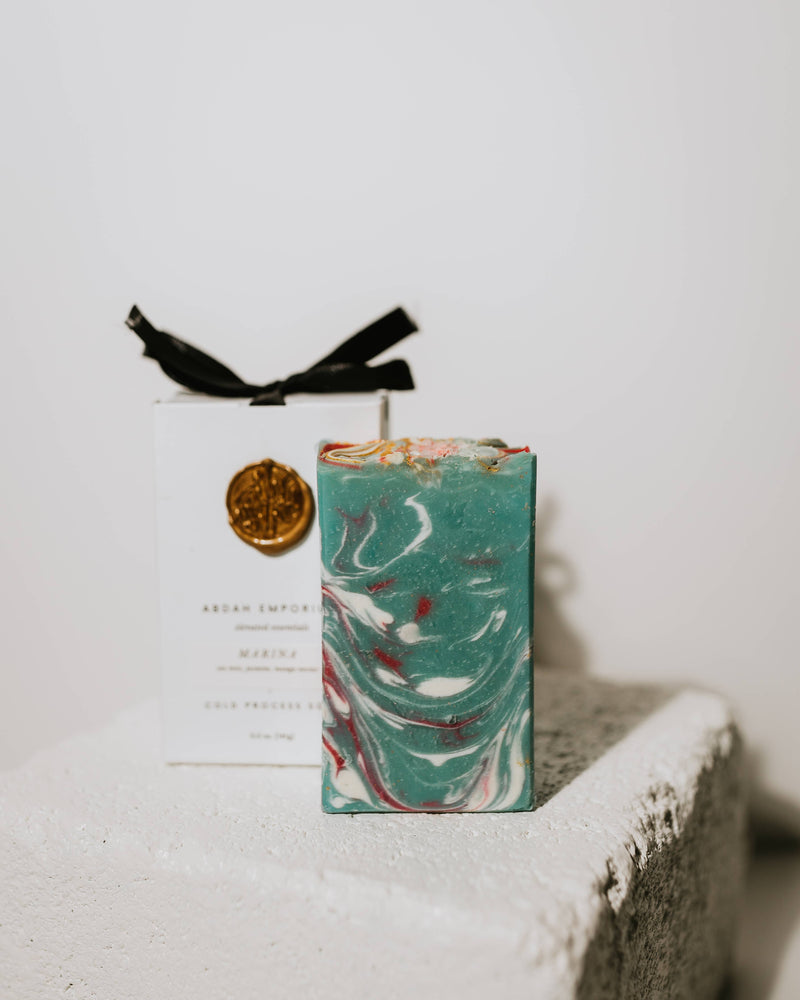 Marbled soap with a black ribbon on a textured surface