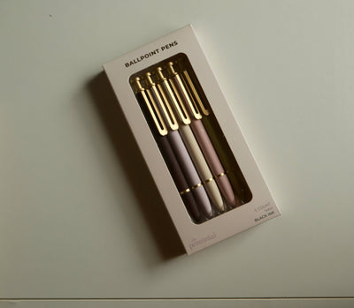 Set of ballpoint pens in a box on a light surface