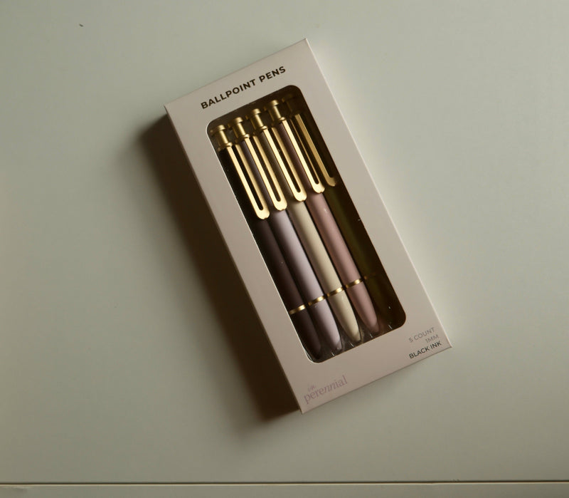 Set of ballpoint pens in a box on a light surface