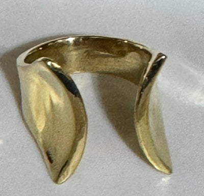 Gold ring with a unique design on a light gray background